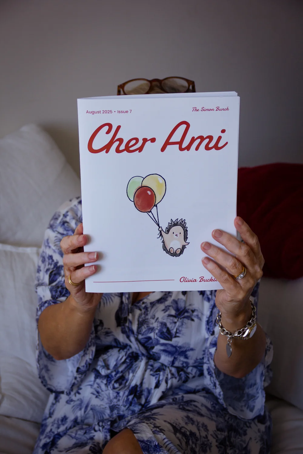 A grandmother holding up her Cher Ami magazine
